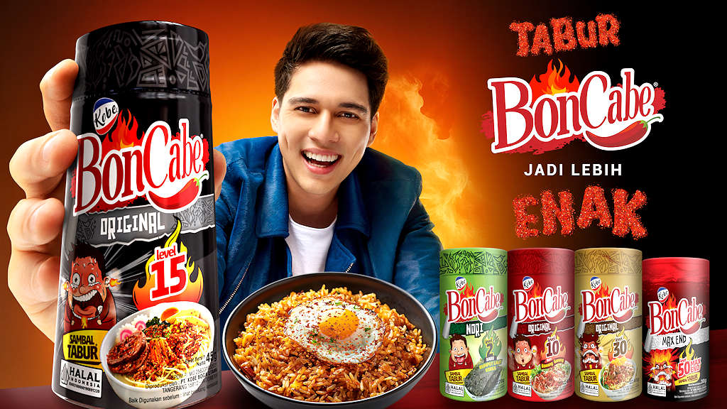 Pria memegang botol BonCabe sambal tabur Level 15 dengan nasi goreng dan telur di depannya, latar api oranye, teks Tabur BonCabe jadi lebih enak.