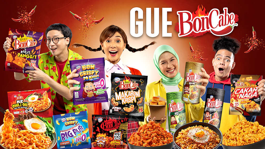 Banner yang cerah menampilkan empat orang yang memperlihatkan produk camilan BonCabe. Dua pria dan dua wanita dengan antusias menunjukkan berbagai rasa dari camilan tersebut di depan latar belakang merah dengan logo GUE BonCabe dan cabai merah yang bertaburan. Beberapa mangkuk makanan pedas melengkapi gambar, menekankan sifat pedas dari camilan tersebut.