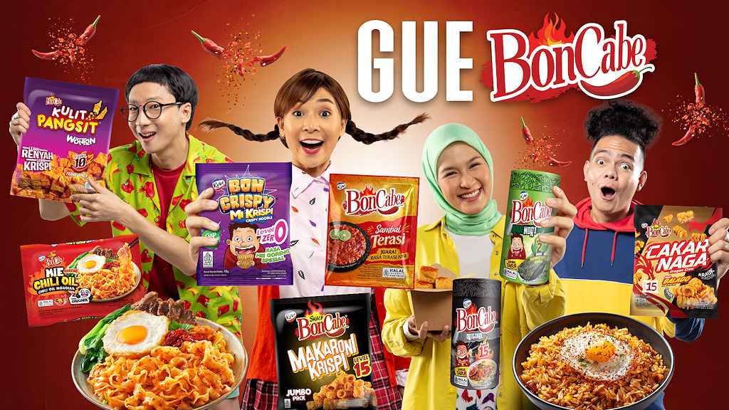 Banner yang cerah menampilkan empat orang yang memperlihatkan produk camilan BonCabe. Dua pria dan dua wanita dengan antusias menunjukkan berbagai rasa dari camilan tersebut di depan latar belakang merah dengan logo GUE BonCabe dan cabai merah yang bertaburan. Beberapa mangkuk makanan pedas melengkapi gambar, menekankan sifat pedas dari camilan tersebut.